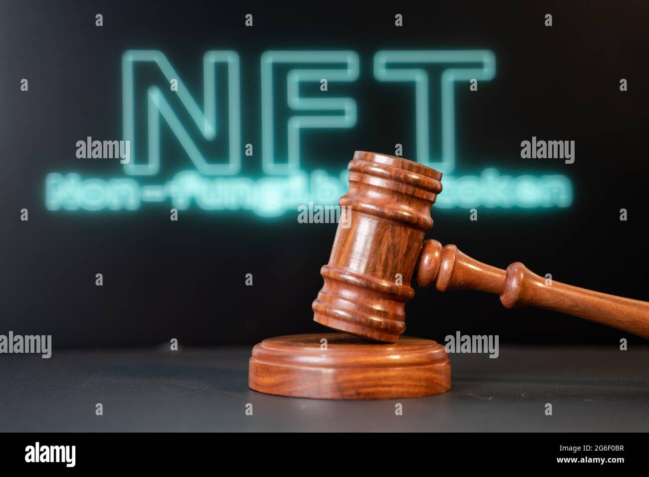 Concept montrant NFT ou jeton non fongible enchère ou enchère en utilisant un marteau de vente aux enchères avec NFT écrit en arrière-plan Banque D'Images