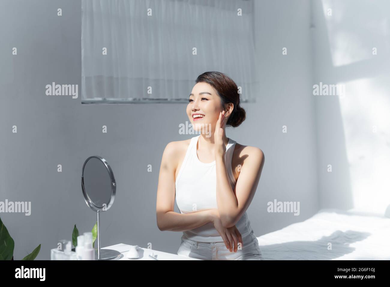 Portrait de la belle jeune femme asiatique sourire tout en se réveillent sain et bien-être avec le lever du soleil le matin dans la chambre Banque D'Images