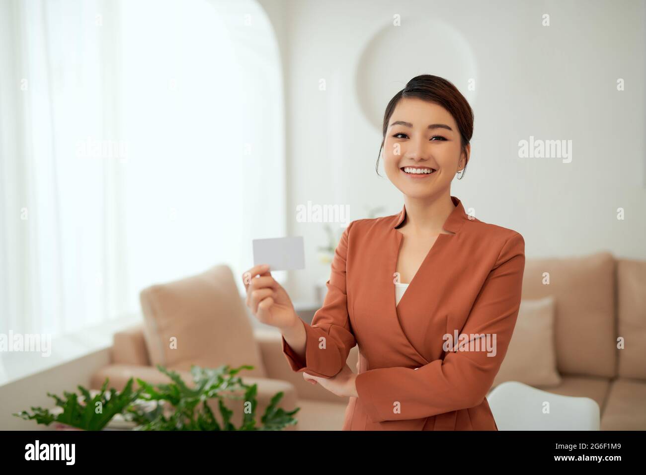 Femme d'affaires tenant et montrant une carte de visite blanche ou un nom de carte vierge entre les mains. Banque D'Images