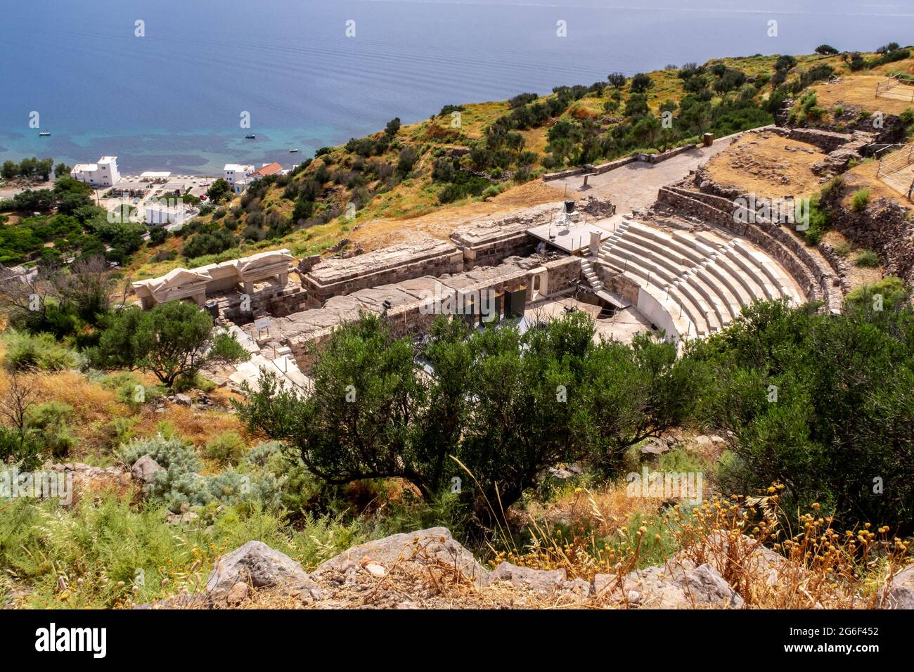 Ruines de l'ancien théâtre de Milos sur une colline verdoyante avec la mer Méditerranée en arrière-plan près de la ville de Trypiti sur l'île de Milos, Grèce. Banque D'Images