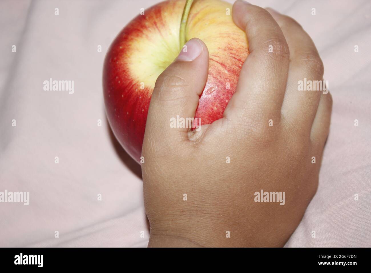 Un petit enfant mangeant une pomme rouge. Banque D'Images