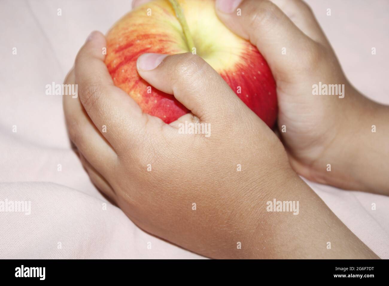 Un petit enfant mangeant une pomme rouge. Banque D'Images