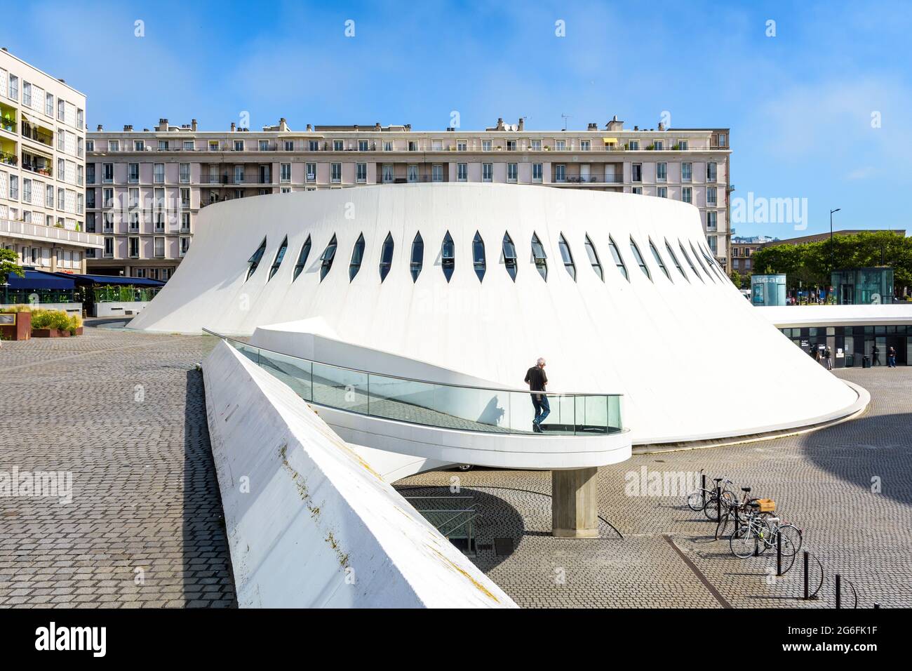 Un homme descend la rampe en spirale à côté du 'petit volcan' qui abrite la bibliothèque publique Oscar Niemeyer au Havre, en France. Banque D'Images