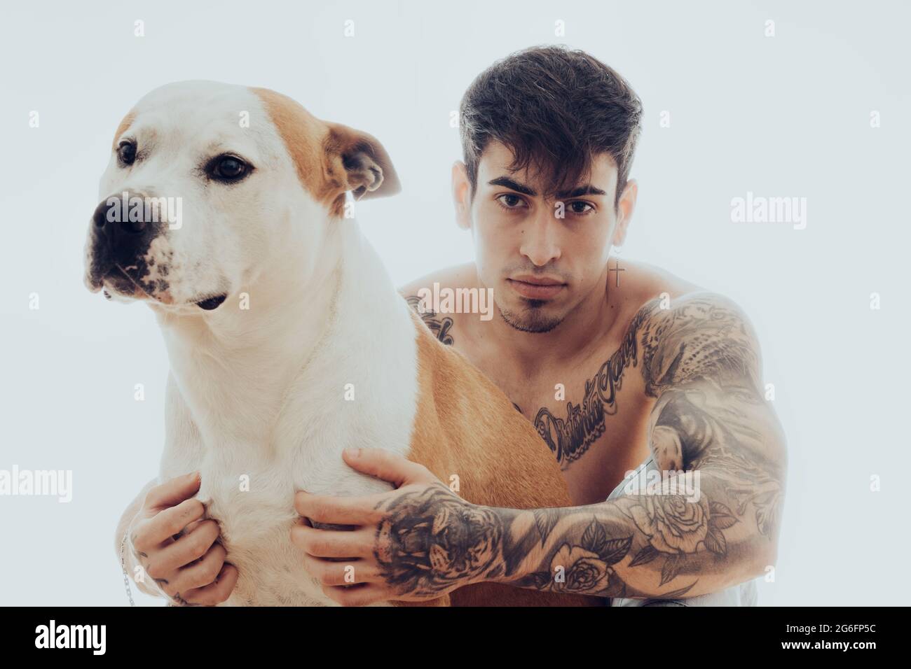 Portrait d'un jeune homme avec des tatouages et un chien Banque D'Images