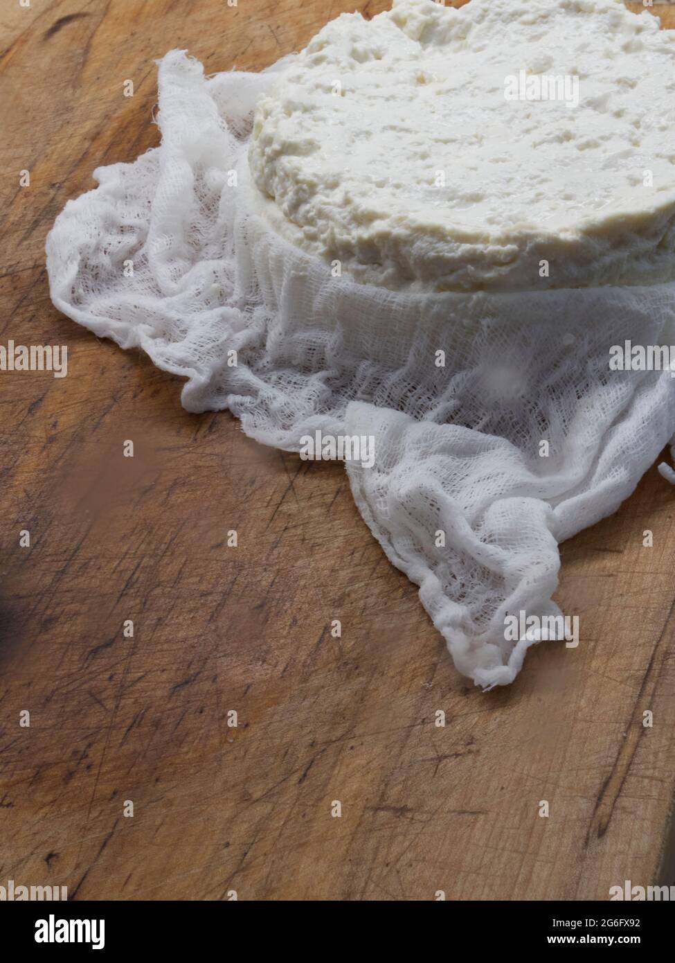 Maison, bricolage, fromage feta frais dans un tissu de fromage sur bois Banque D'Images