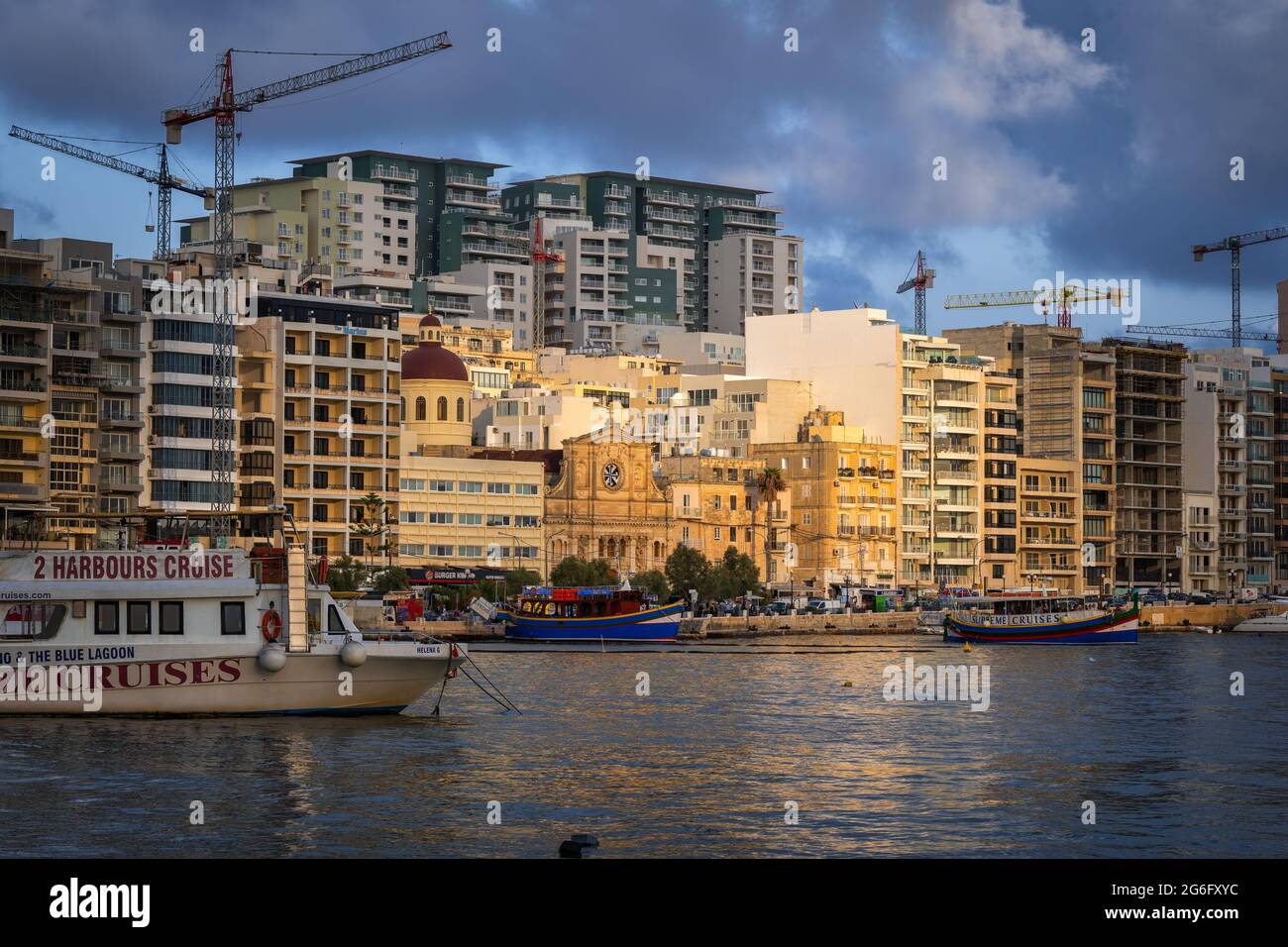 Coucher de soleil sur la ville de Sliema à Malte, vue sur la ligne d'horizon depuis le port de Marsamxett dans la mer Méditerranée. Banque D'Images