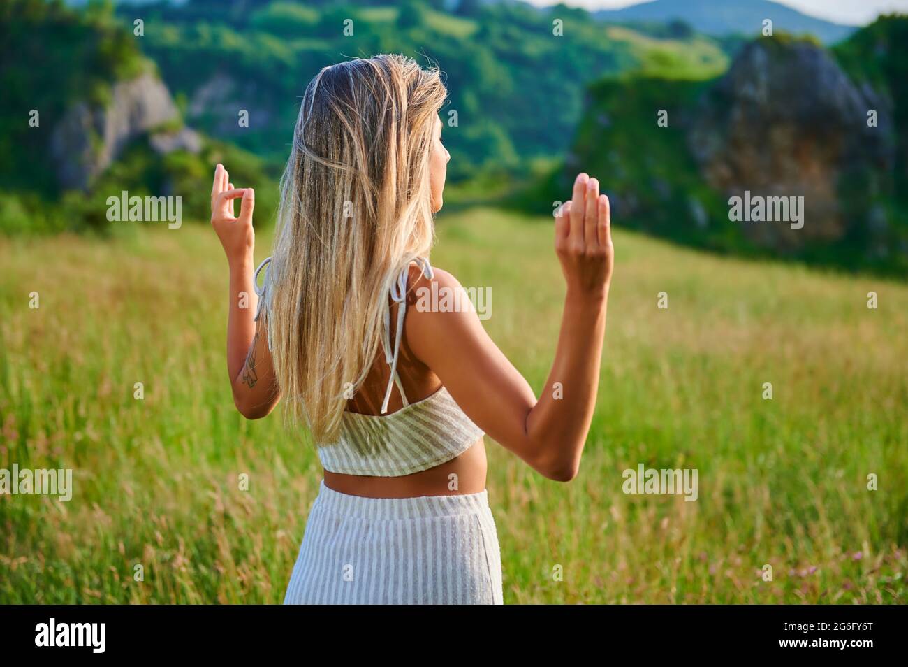 jeune femme blonde pratiquant la méditation sur la montagne Banque D'Images