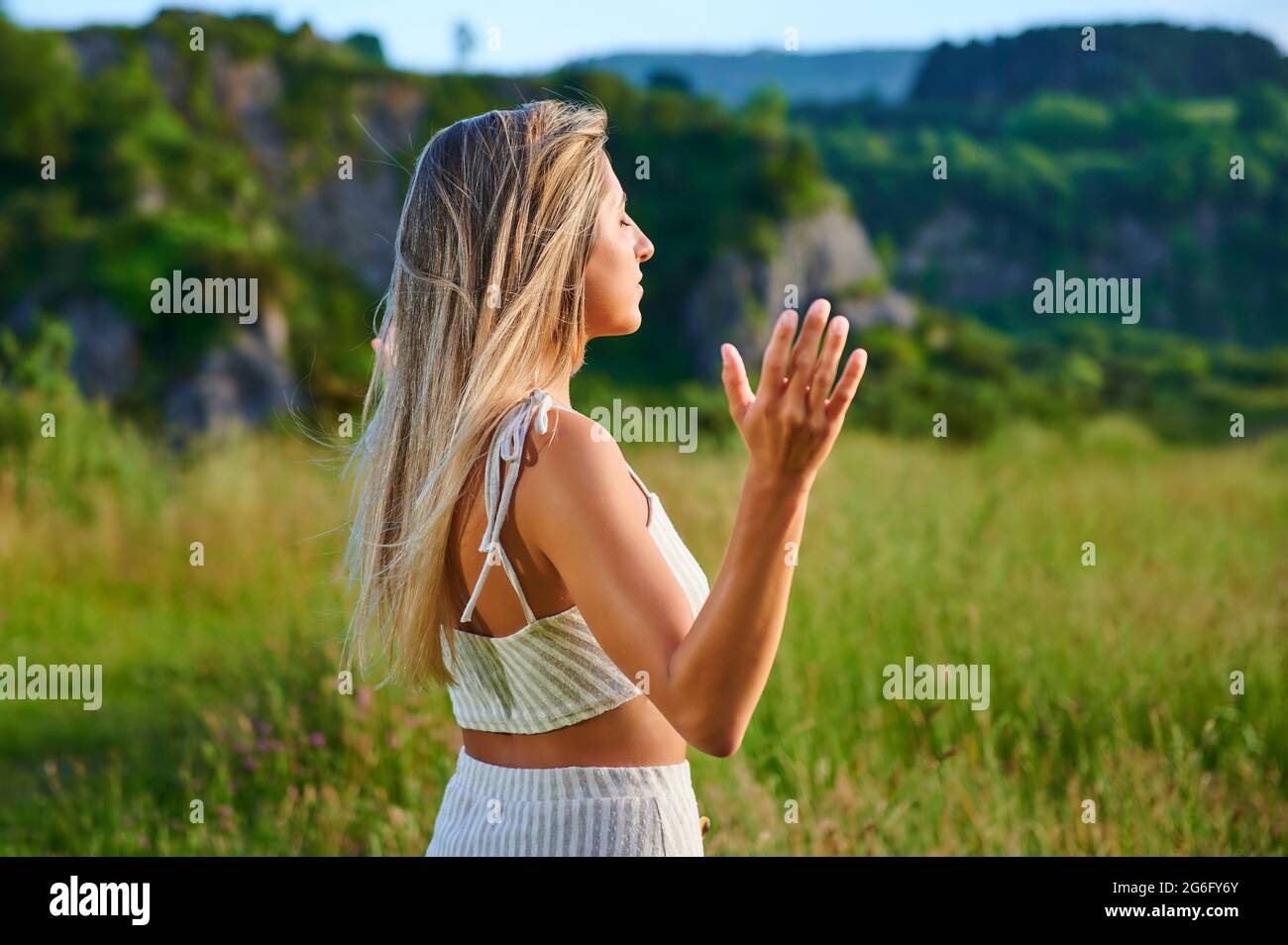 jeune femme blonde pratiquant la méditation sur la montagne Banque D'Images