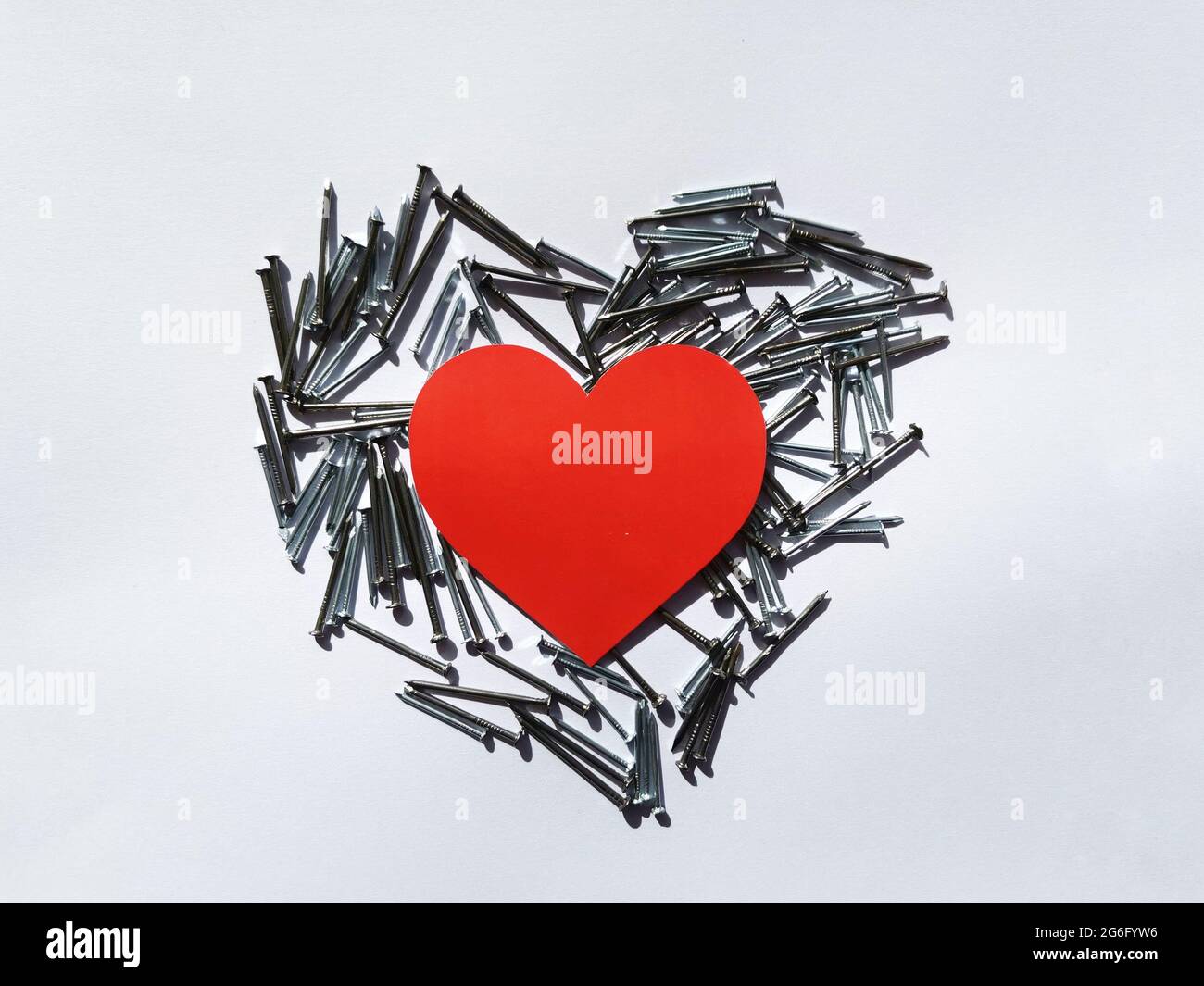 Cœur rouge. Cœur à partir de clous métalliques. Arrière-plan blanc, pointes de coeur et cœur rouge. Saint Valentin. Banque D'Images