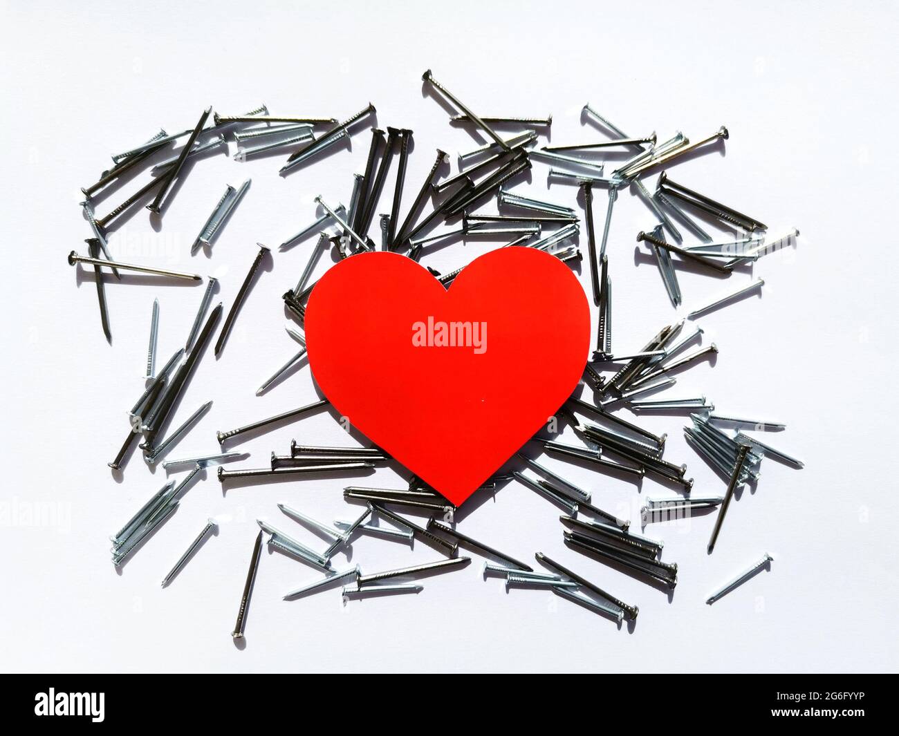 Cœur rouge. Cœur à partir de clous métalliques. Arrière-plan blanc, pointes de coeur et cœur rouge. Saint Valentin. Banque D'Images