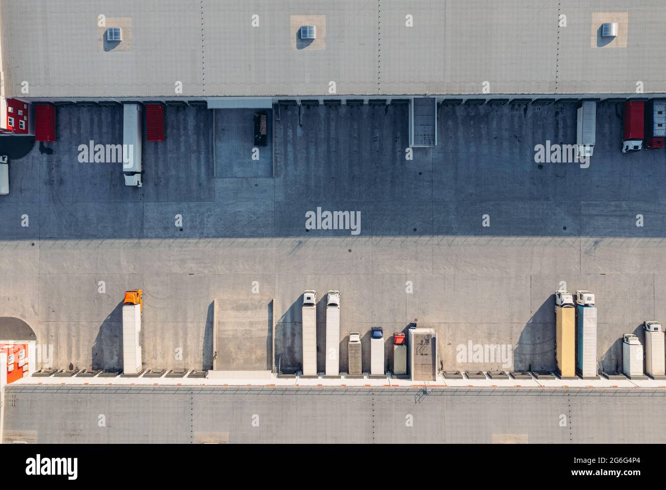 Les camions avec remorques attendent le chargement des marchandises pour le transport dans l'entrepôt de chargement. Vue aérienne de dessus tir de drone. Un grand terminal de transport de marchandises avec des camions et des remorques. Banque D'Images