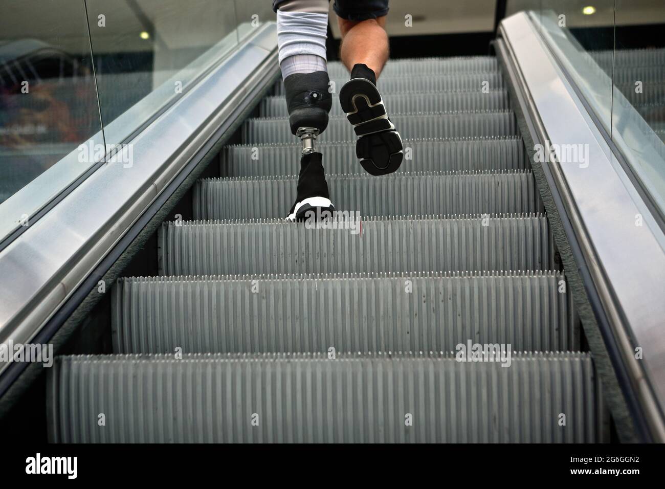 Londres (Royaume-Uni), 6 juillet 2021 : un homme avec une jambe prothétique nie un escalator dans le centre commercial de Londres. Banque D'Images