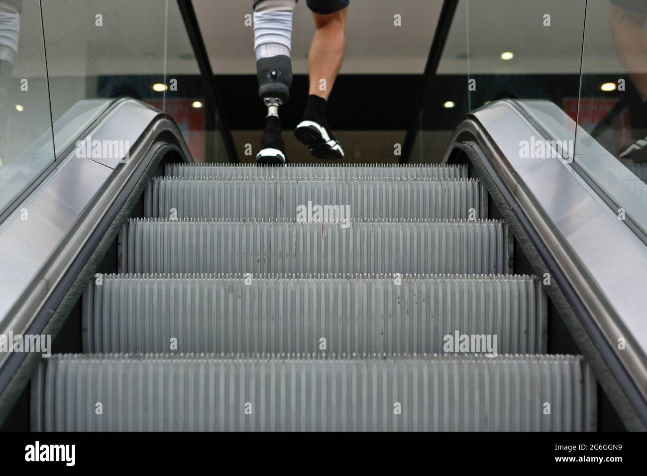 Londres (Royaume-Uni), 6 juillet 2021 : un homme avec une jambe prothétique nie un escalator dans le centre commercial de Londres. Banque D'Images