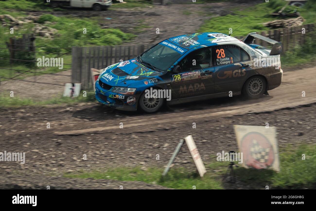 Photo d'action d'une voiture de rallye lors d'une compétition sur des pistes de forst boueuses Banque D'Images