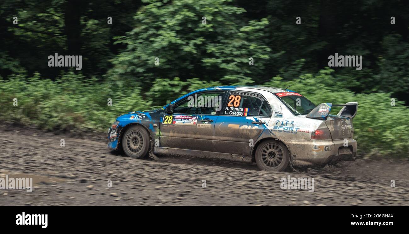 Photo d'action d'une voiture de rallye lors d'une compétition sur des pistes de forst boueuses Banque D'Images