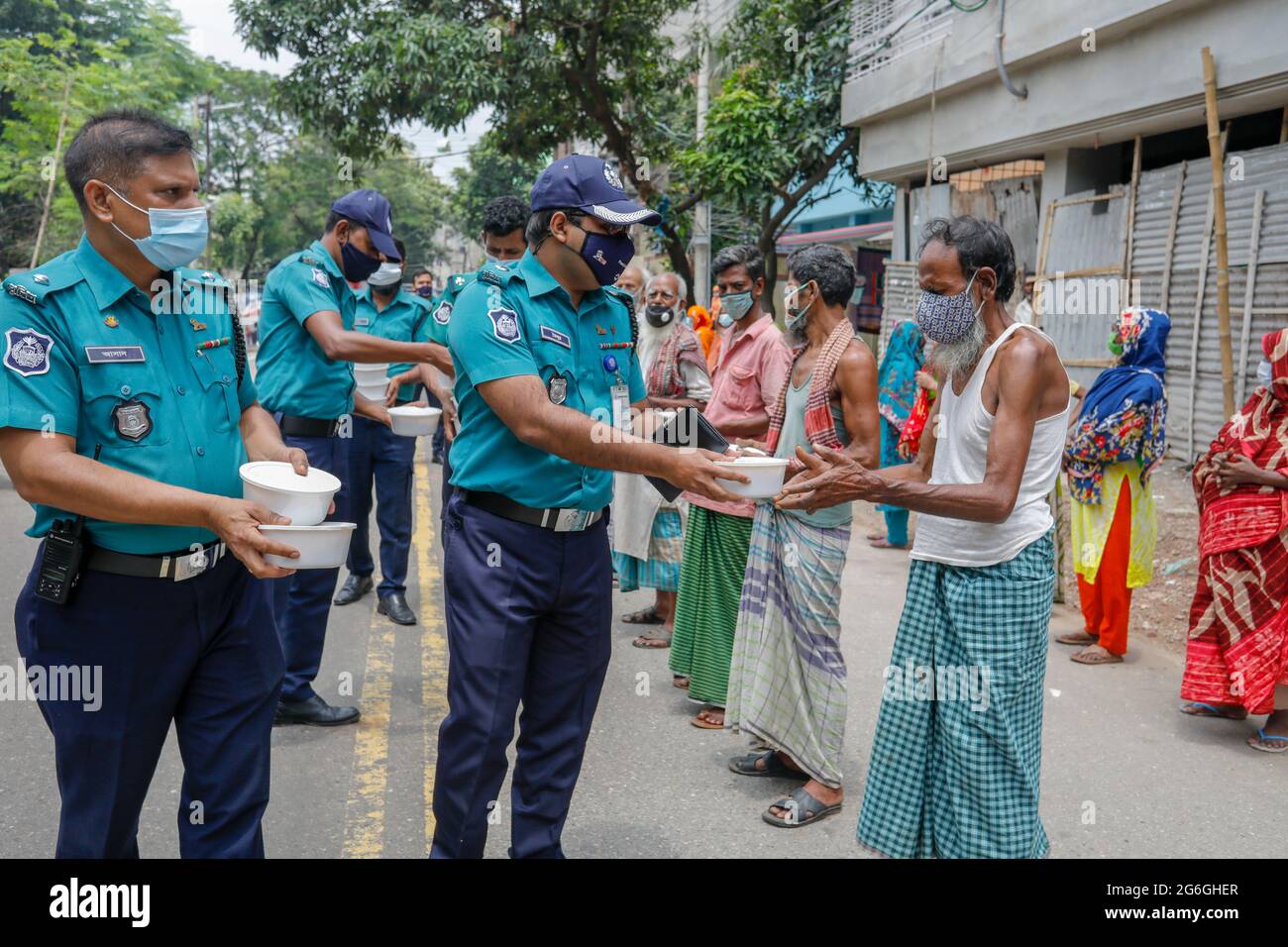 Au cours d'un confinement à l'échelle nationale, les policiers du Bangladesh font don de nourriture gratuite aux populations défavorisées de Dhaka, au Bangladesh, le 6 juillet 2021. Banque D'Images