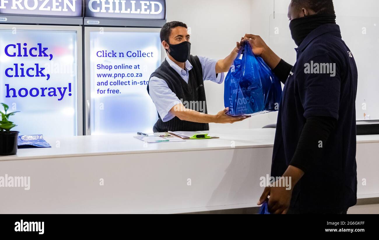 Cape Town, Afrique du Sud - 10 décembre 2020: Express Service à domicile homme de livraison de la collecte de la commande du personnel au comptoir à l'intérieur de l'épicerie locale Pick n Pay Banque D'Images