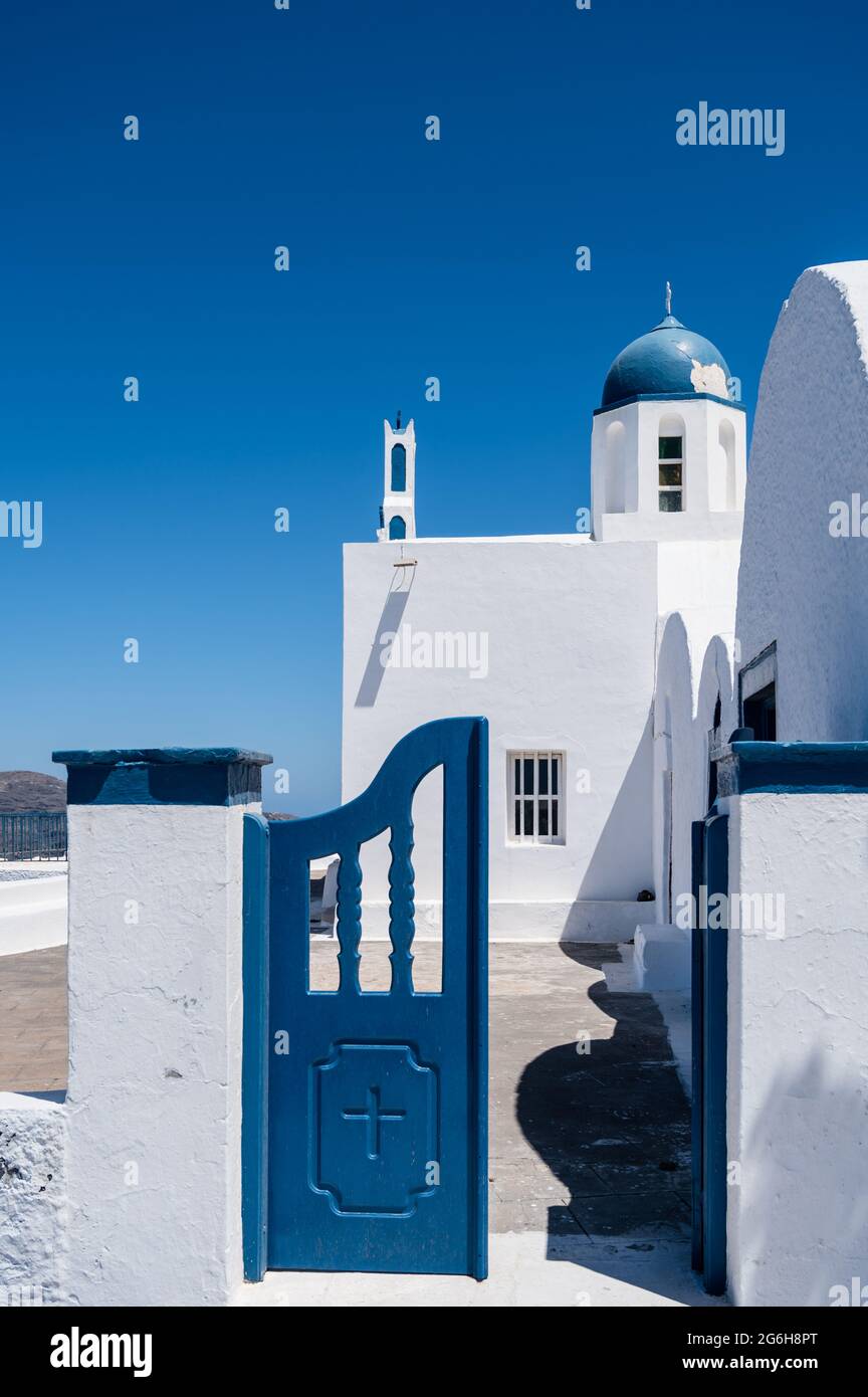 Petite porte en bois de l'église orthodoxe grecque traditionnelle sur l'île de Santorini. Porte bleue ouverte. Jour ensoleillé. Ciel bleu. Personne. Banque D'Images