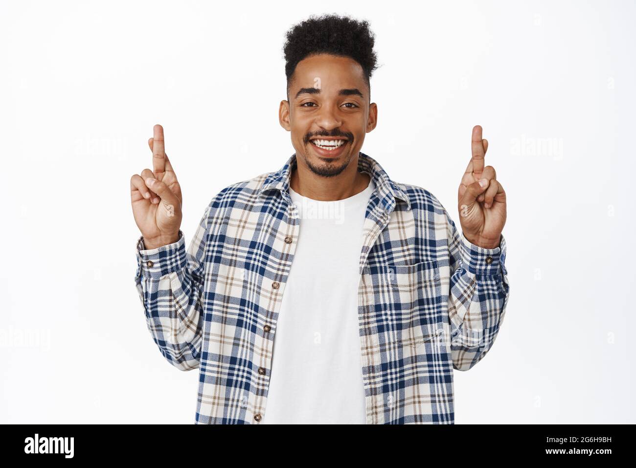 De grands espoirs. Souriant, un jeune afro-américain croiser les doigts pour la bonne chance, faire des vœux, attendre des nouvelles positives, anticiper la relish Banque D'Images