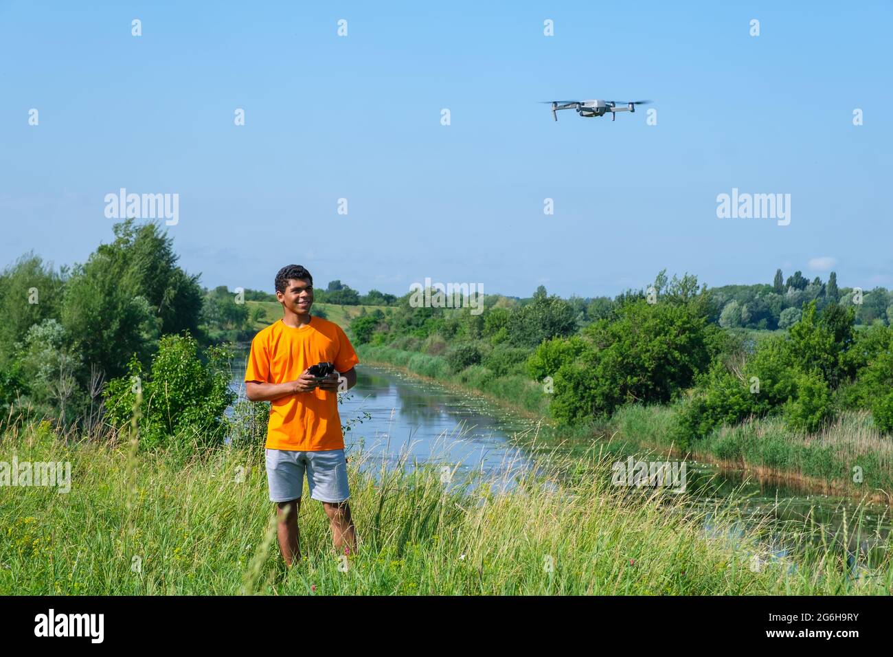 Africain américain homme utilisant un drone avec contrôleur dans les mains sur le pré Banque D'Images