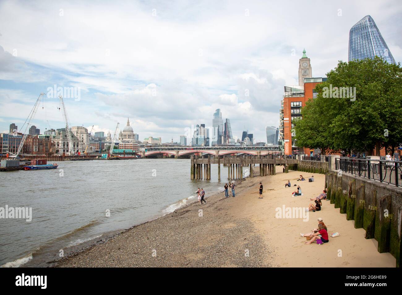 Les gens qui apprécient le temps ensoleillé sur la plage de la Tamise, sur la rive sud de la rivière. Banque D'Images