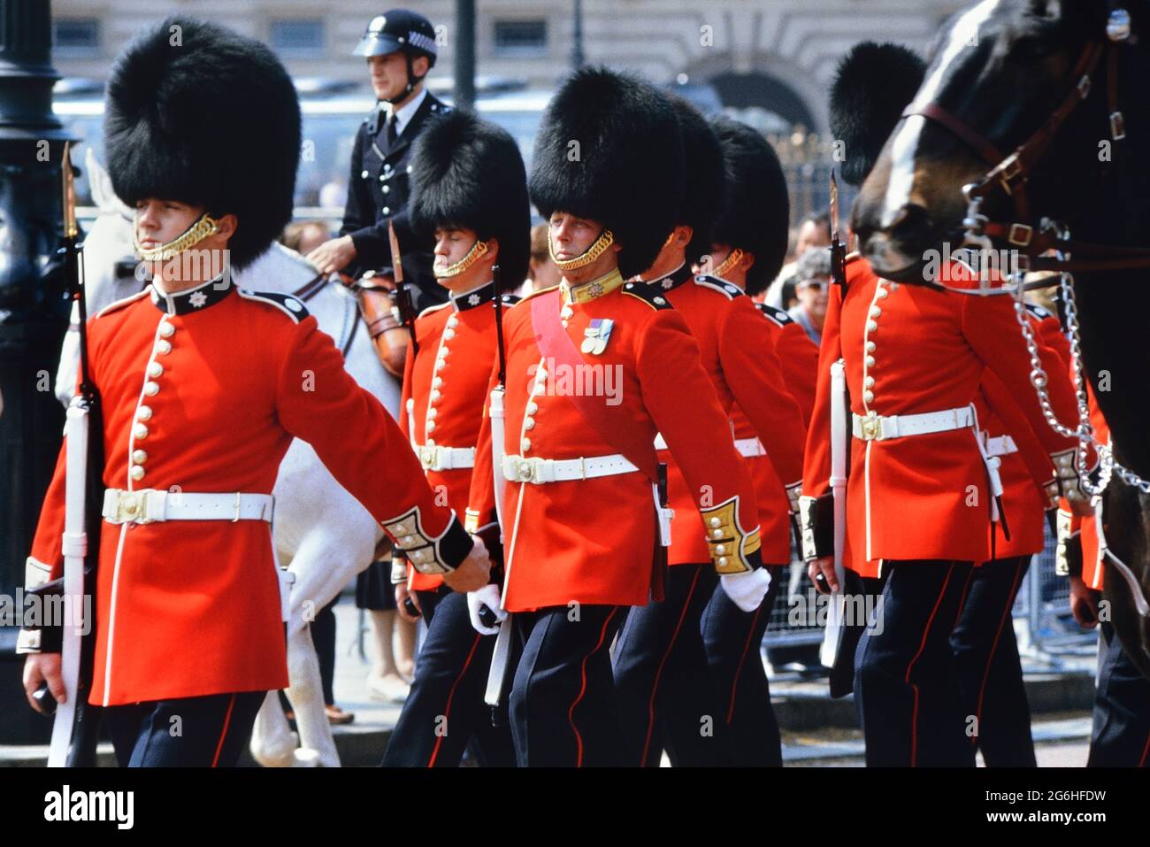 Marching Coldstream Guards, les soldats portant des chapeaux de barbes et des tuniques rouges au changement de la Garde. Buckingham Palace, Londres, Angleterre, Royaume-Uni. Vers les années 1980 Banque D'Images