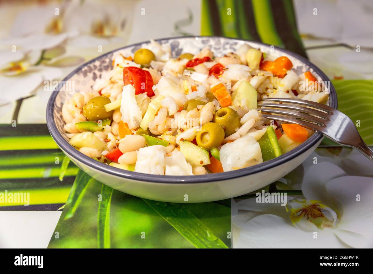 gros plan d'une salade de haricots blancs avec de la morue dans une assiette ronde Banque D'Images