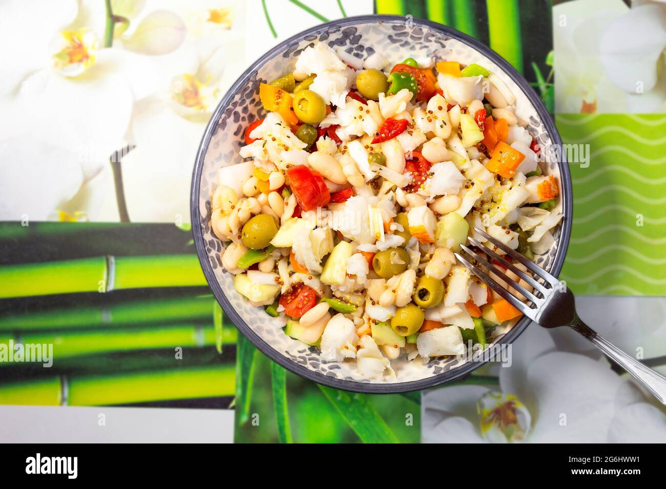 gros plan d'une salade de haricots blancs avec de la morue dans une assiette ronde Banque D'Images