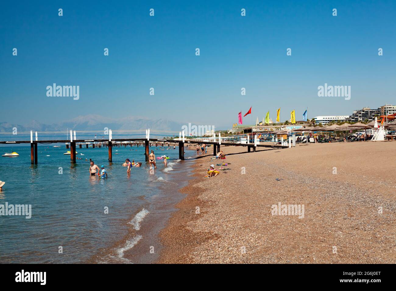 Antalya, Turquie-juin 29, 2021: Personnes marchant sur la côte, nager et bronzer sous des parasols sur la plage en été à Antalya. Banque D'Images