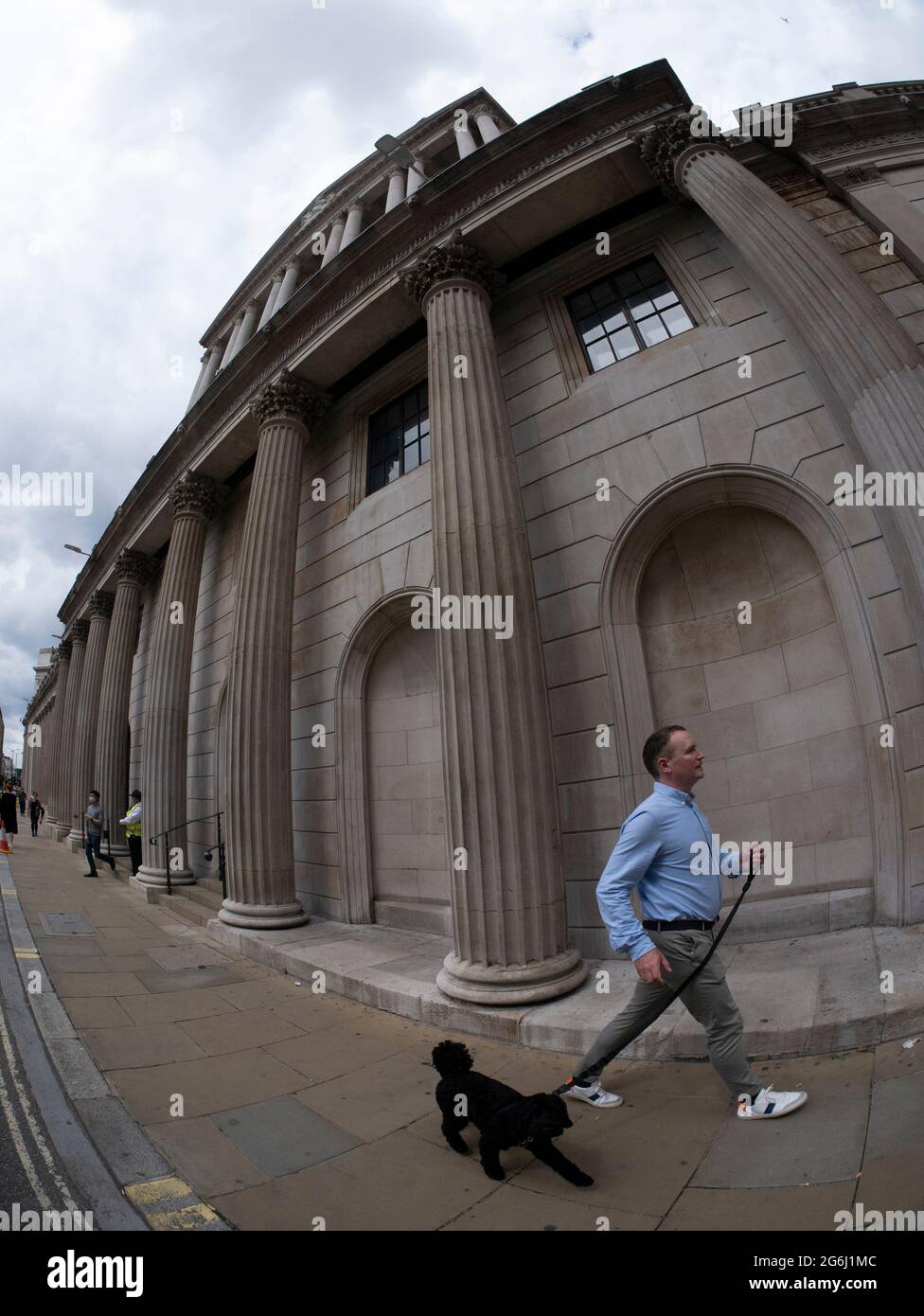 L'homme marche le chien devant la Banque d'Angleterre Threadneedle Street Londres Banque D'Images