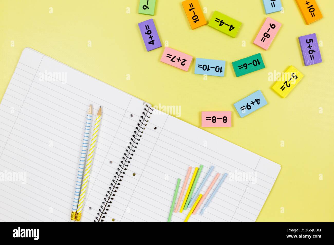 Ouvrez le carnet, les crayons et les exemples mathématiques sur fond jaune. De retour à l'école, apprendre à compter pour les enfants. Banque D'Images
