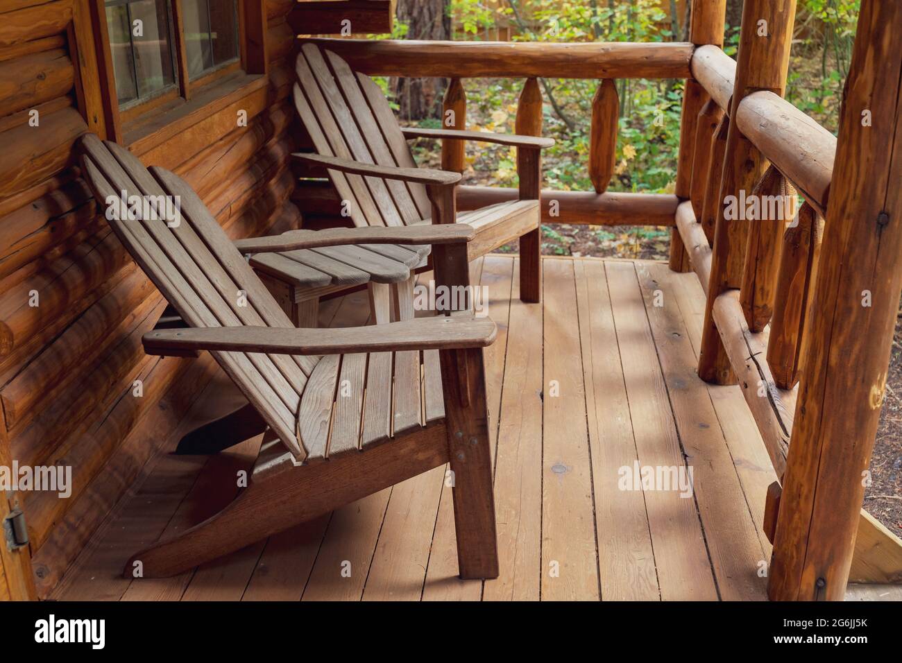 Chaises Adirondack en bois sur le porche de la cabane rustique en bois Banque D'Images