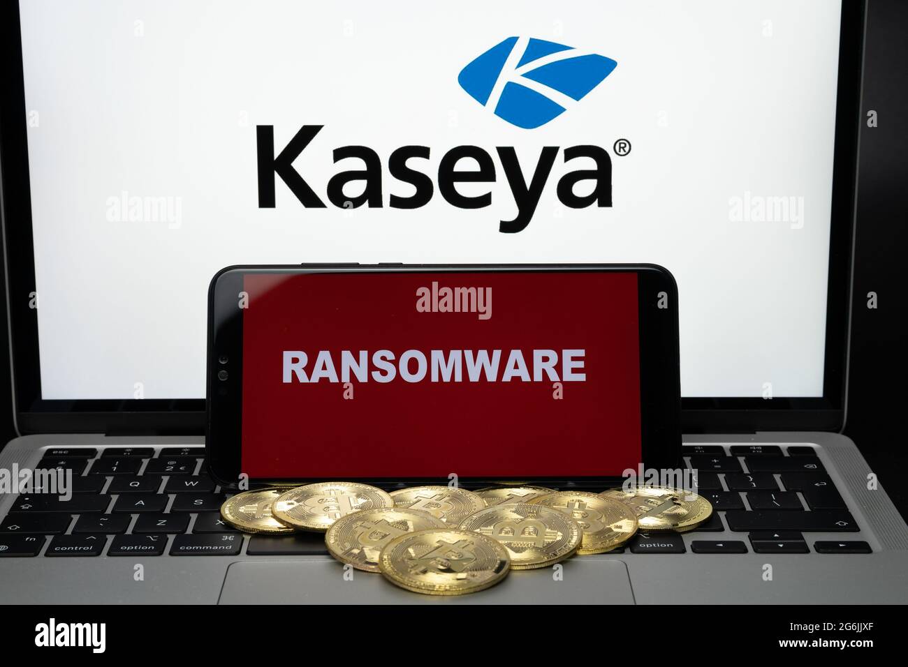 Smartphone avec mots RANSOMWARE et bitcoins flous et logo Kaseya sur ordinateur portable. Concept d'attaque ransomware et de violation de sécurité. Stafford, États-Unis Banque D'Images