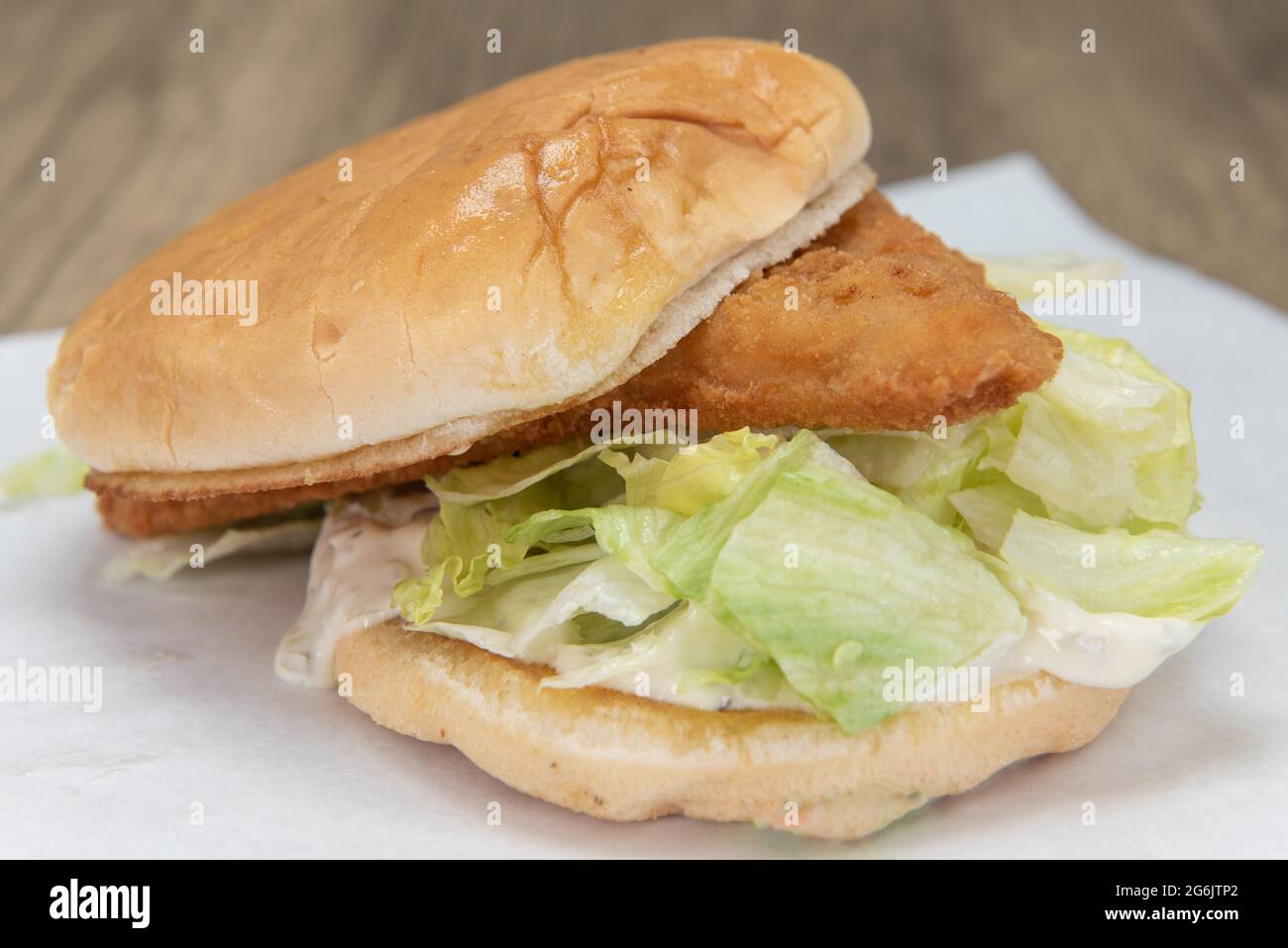 Sandwich au poisson copieux avec filet pané sur un lit de laitue et garnitures pour un repas parfait. Banque D'Images