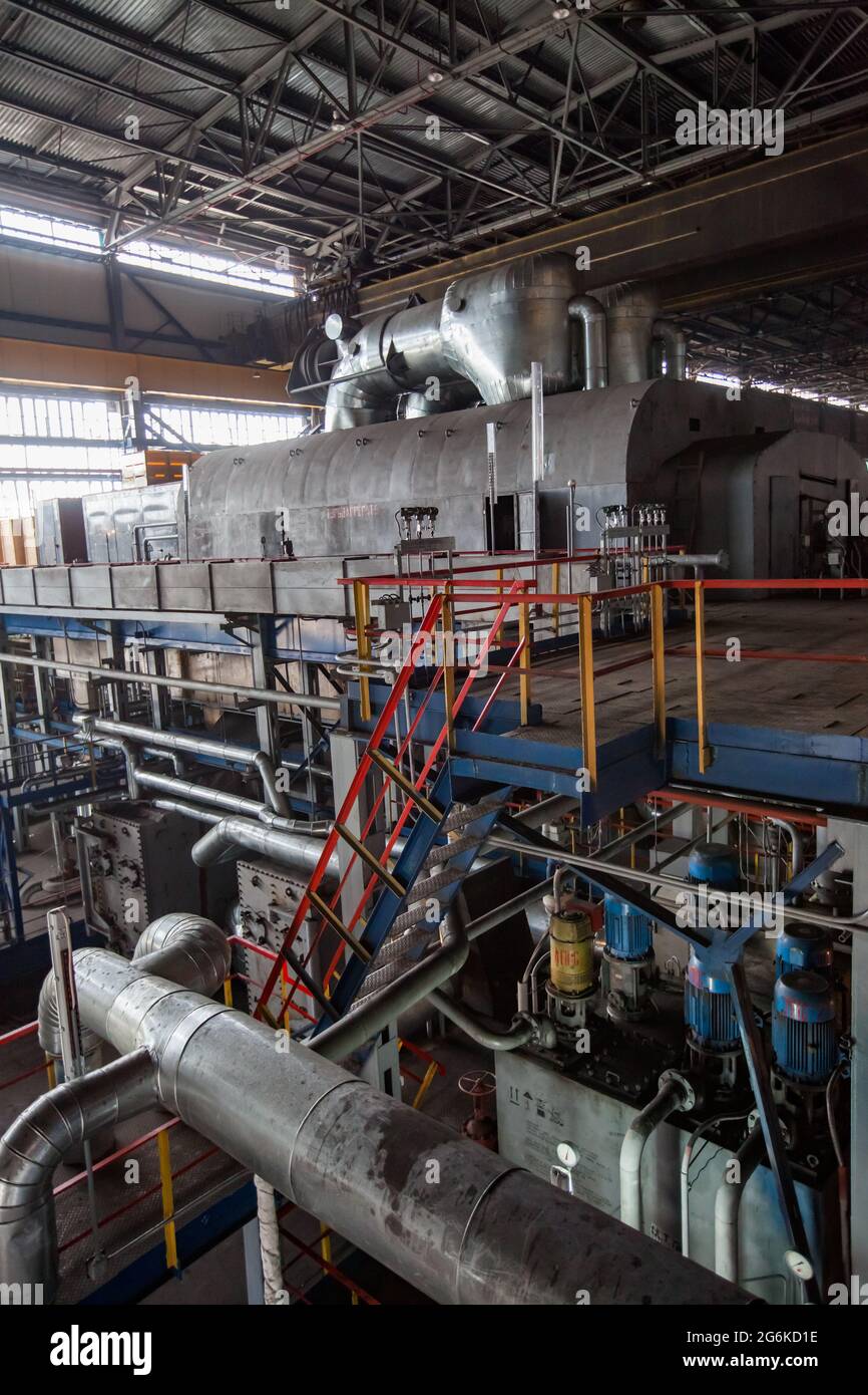 Karagandy, Kazakhstan - 08 juin 2012 : salle des machines de la centrale thermique. Turbine à vapeur gauche. Moteurs de pompe bleus en bas. Escalier et plafond en métal. Banque D'Images