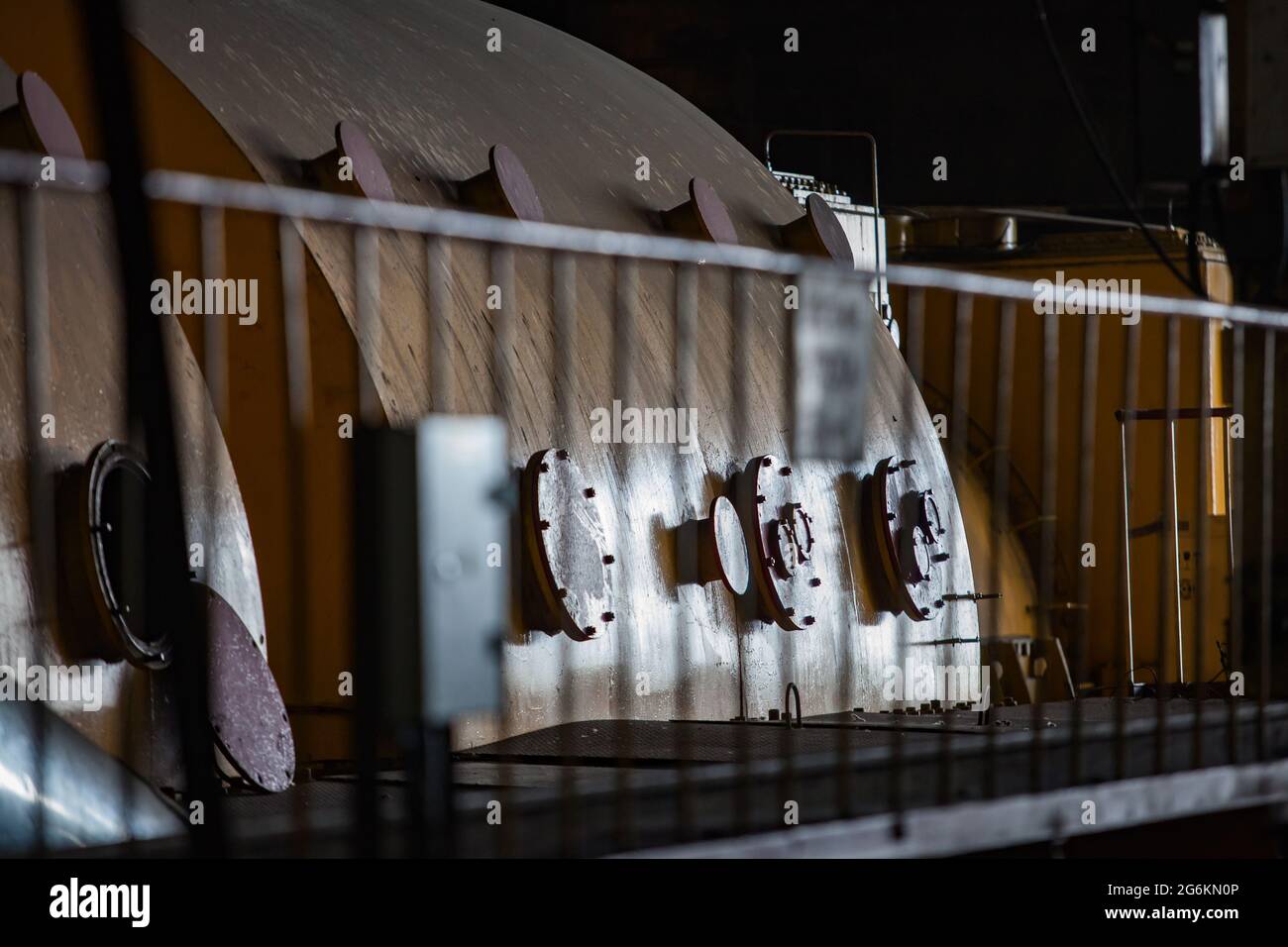 Centrale électrique. Gros plan du corps de la turbine à vapeur. Arrière-plan noir. Clôture de sécurité à l'avant. Banque D'Images