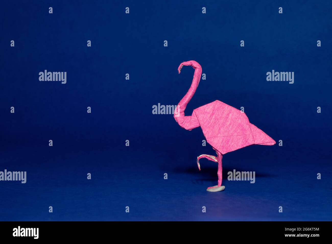 Origami d'un Flamingo sur fond bleu Banque D'Images