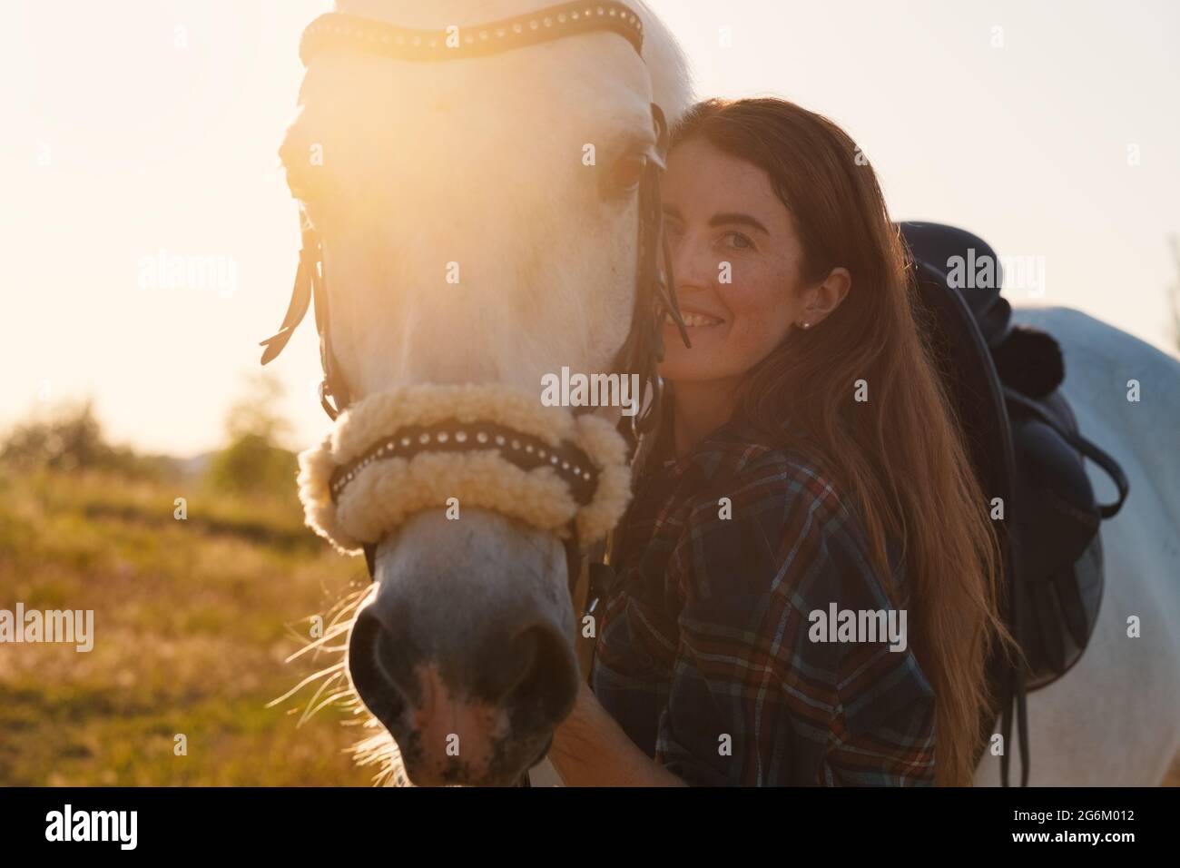 Jeune femme prendre soin de son cheval Banque D'Images