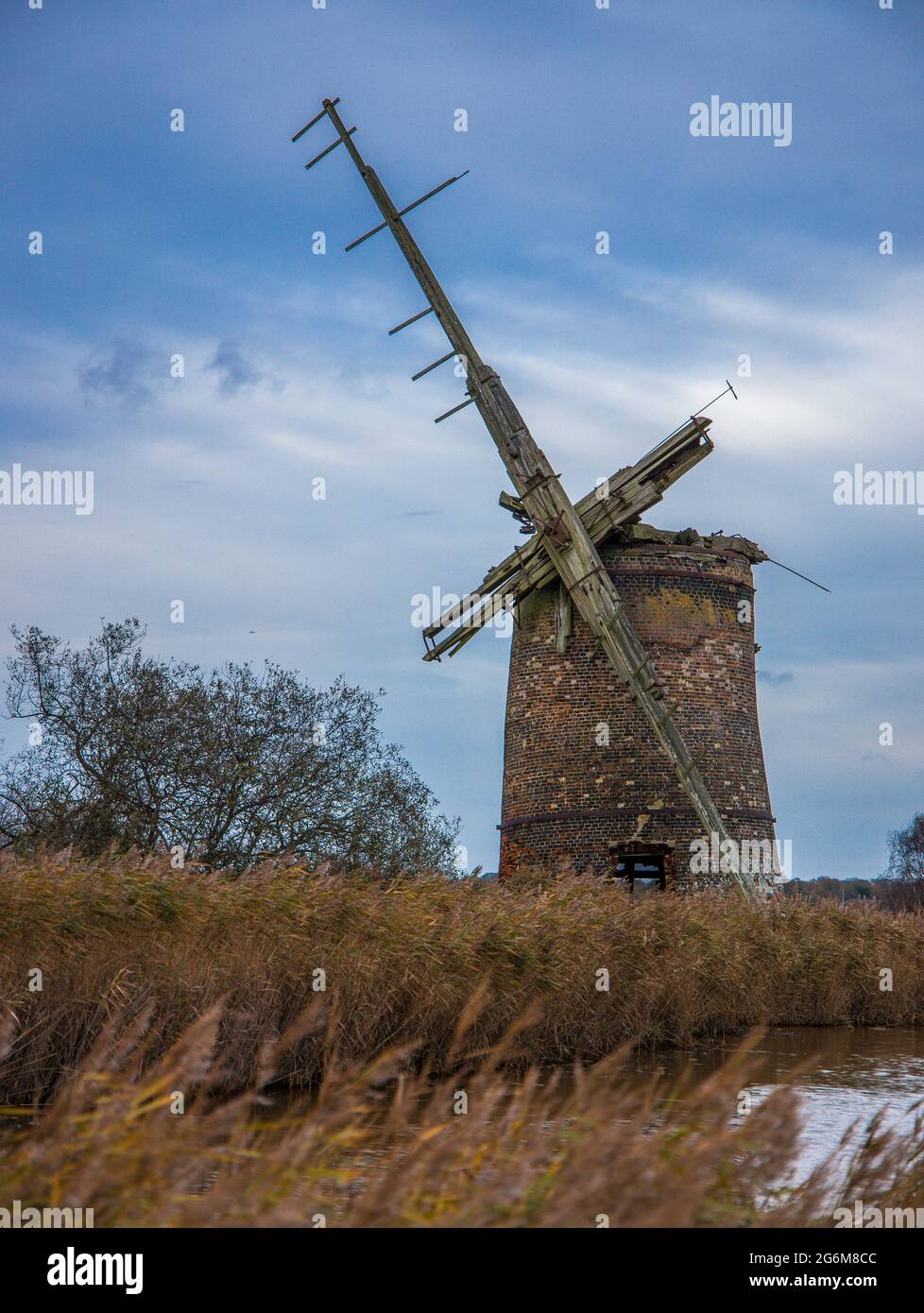 Vue sur le terrain et l'eau d'un moulin à vent à pompe en ruines à Horsey on the Boards à Norfolk en Angleterre Banque D'Images