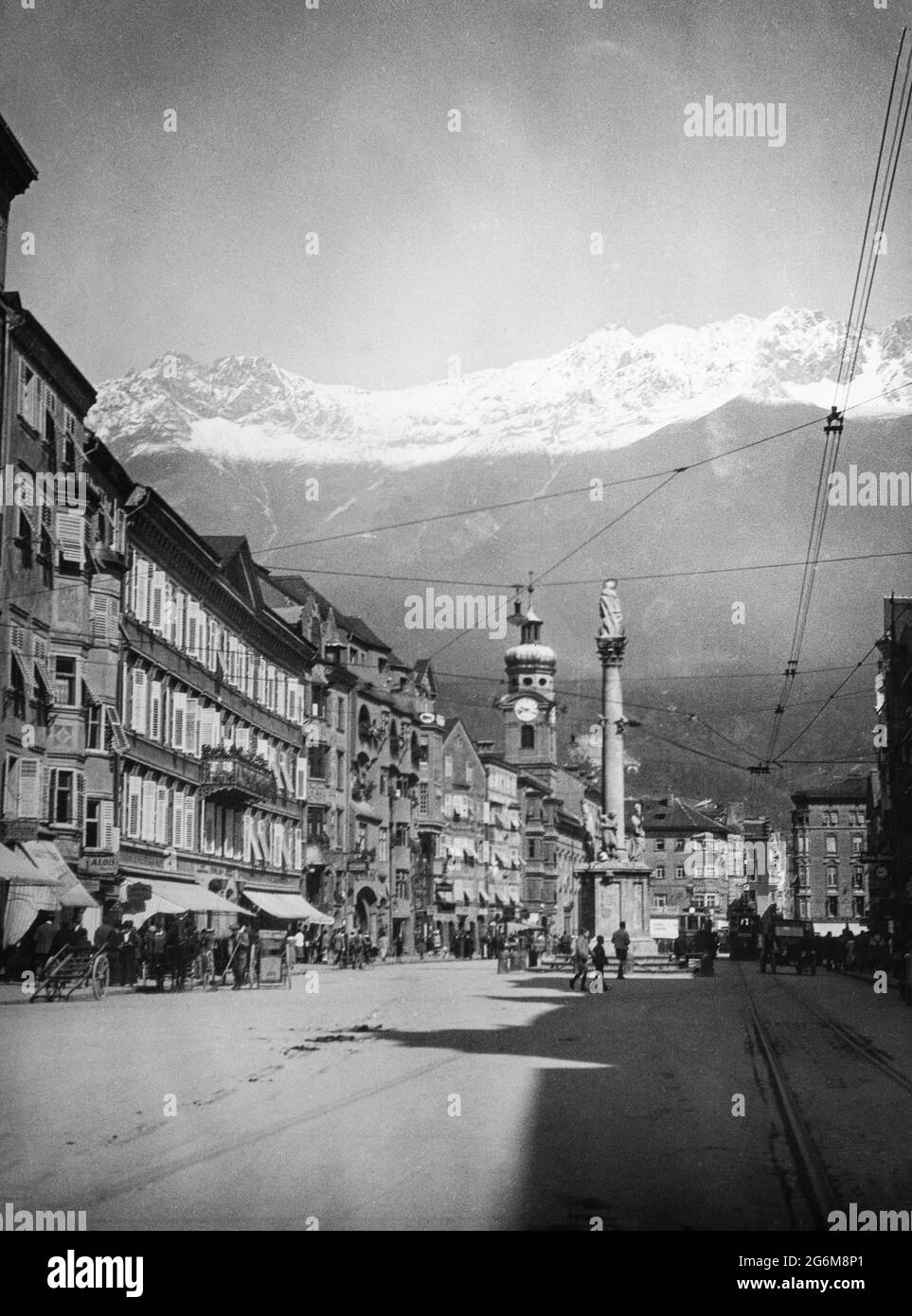 Une photographie noir et blanc vintage du début du XXe siècle montrant Innsbruck en Autriche. Vue sur Thereslan Strassa, avec les Alpes autrichiennes en arrière-plan. Banque D'Images
