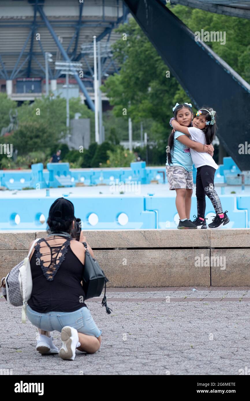 Une mère prenant un téléphone portable photos de 2 filles adorables. Dans le parc Corona de Flushing Meadows près de l'Unispahere dans Queens, New York. Banque D'Images