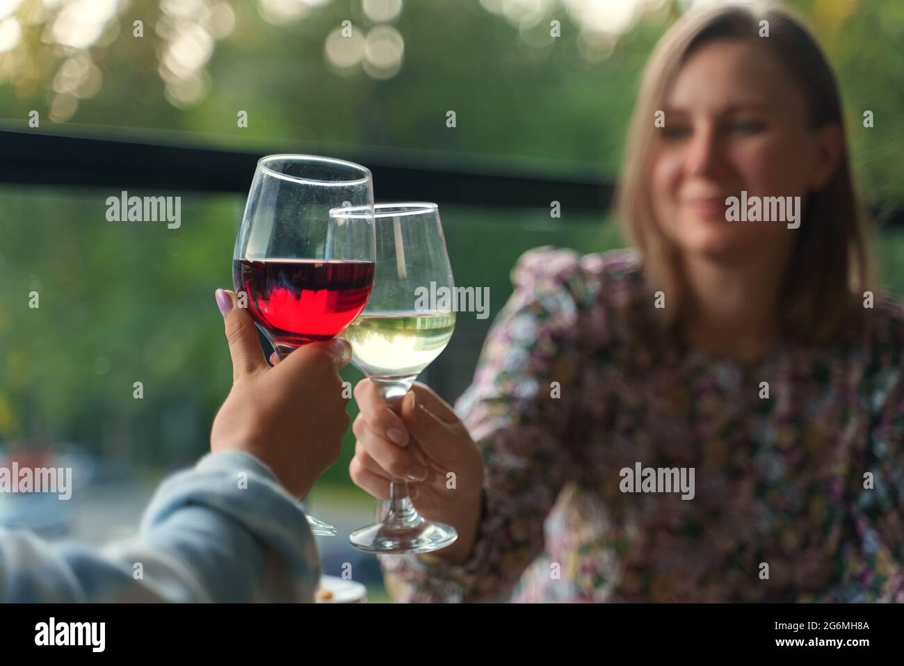 Deux amis boivent du vin sur le balcon en vacances. Banque D'Images