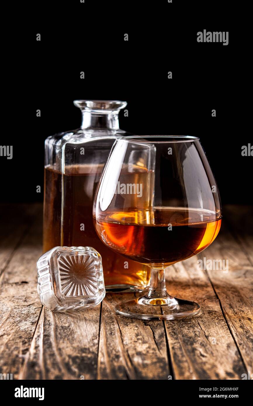 Boisson au Cognac sur table en bois et terrain noir Banque D'Images