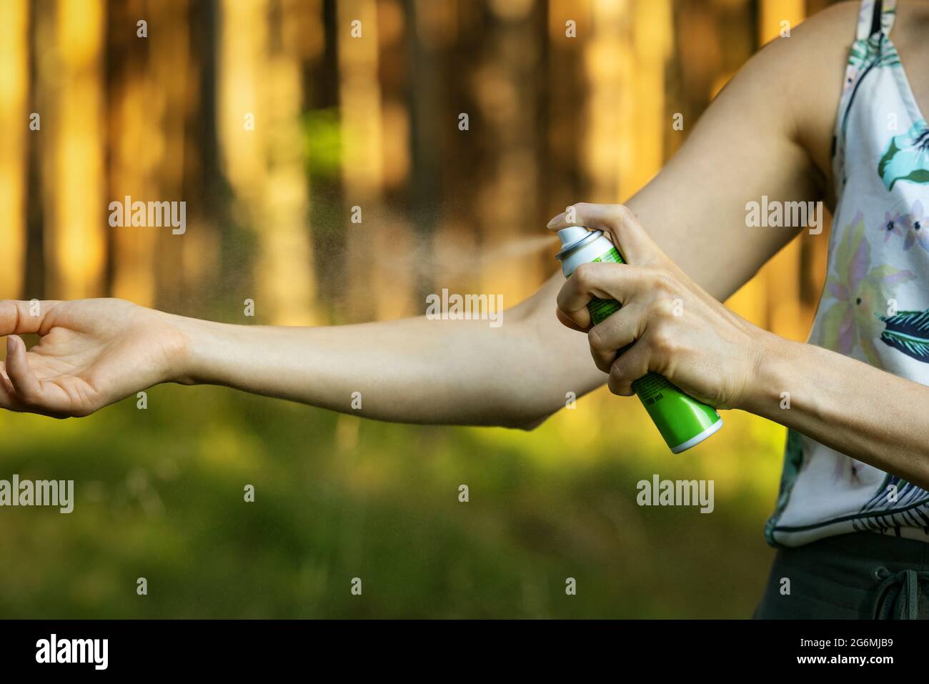 femme appliquant un spray répulsif anti-moustiques et anti-insectes sur la main en forêt Banque D'Images