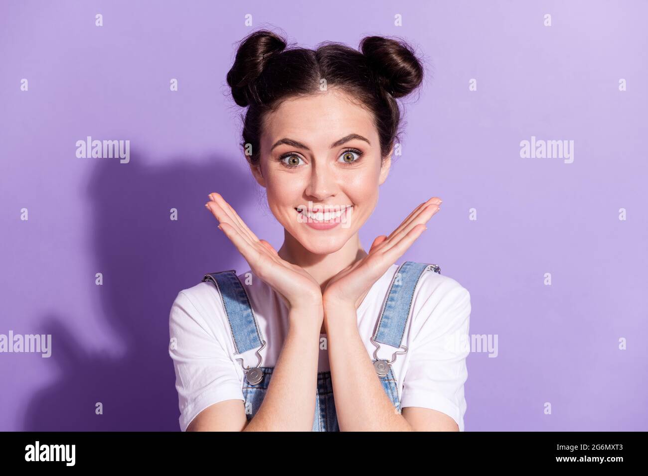 Photo de la jeune fille attrayante heureux positif sourire toothy bun isolé sur fond violet de couleur Banque D'Images