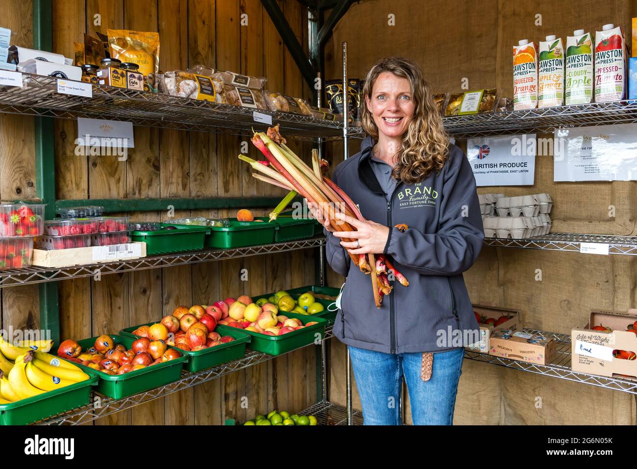 Assistant-boutique avec rhubarbe, fruits et légumes frais, larder de la famille Brand, East Fortune Farm, East Lothian, Écosse, ROYAUME-UNI Banque D'Images