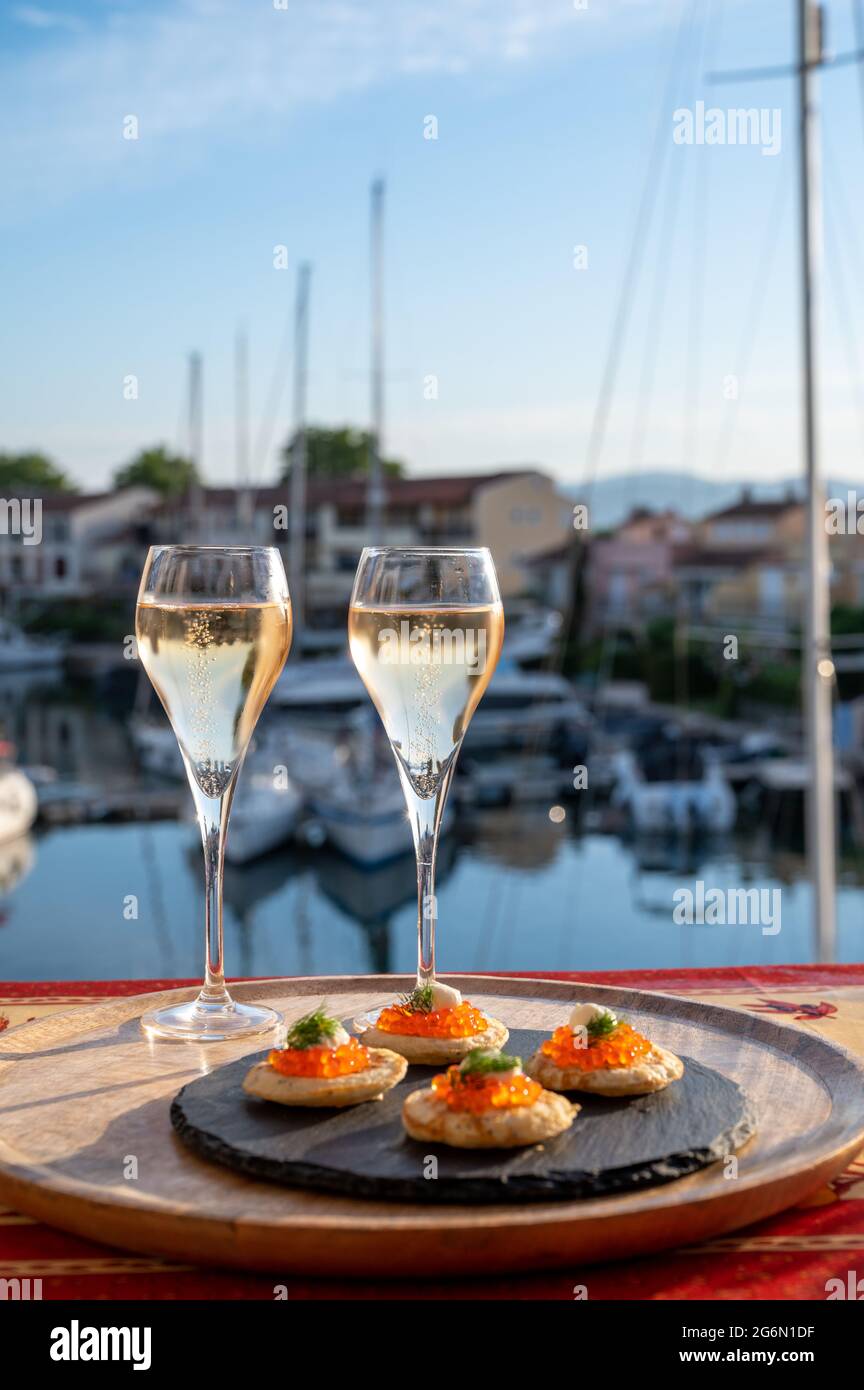Fête de style russe avec deux verres de champagne blanc froid, blinny au  caviar rouge et vue sur Port Grimaud près de Saint-Tropez, vacances sur le  RIV français Photo Stock - Alamy