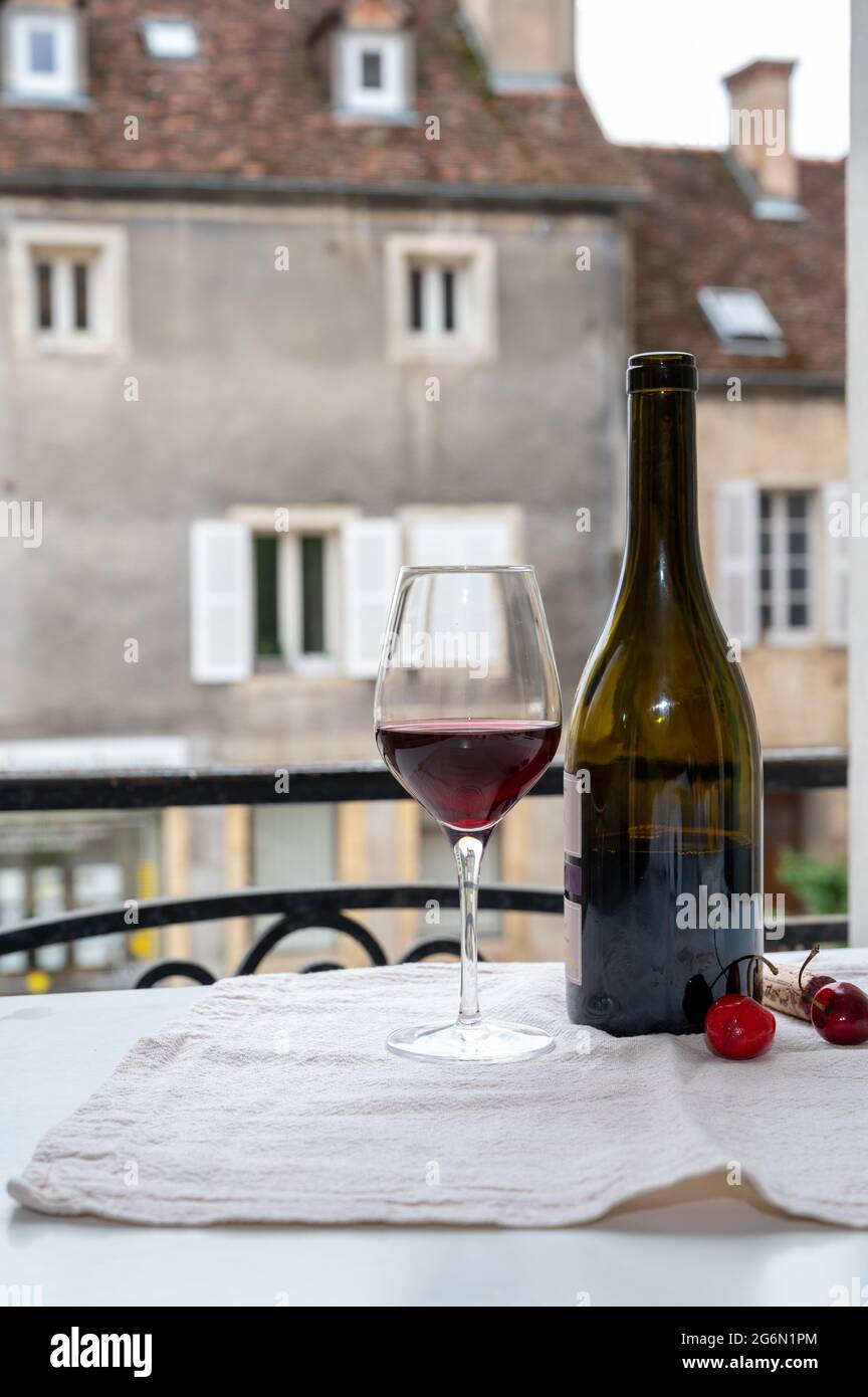 Dégustation de vin rouge bordeaux des grands vignobles cru Pinot noir, verre et bouteille de vin rouge et vue sur la vieille ville dans la région viticole de Bourgogne, F Banque D'Images