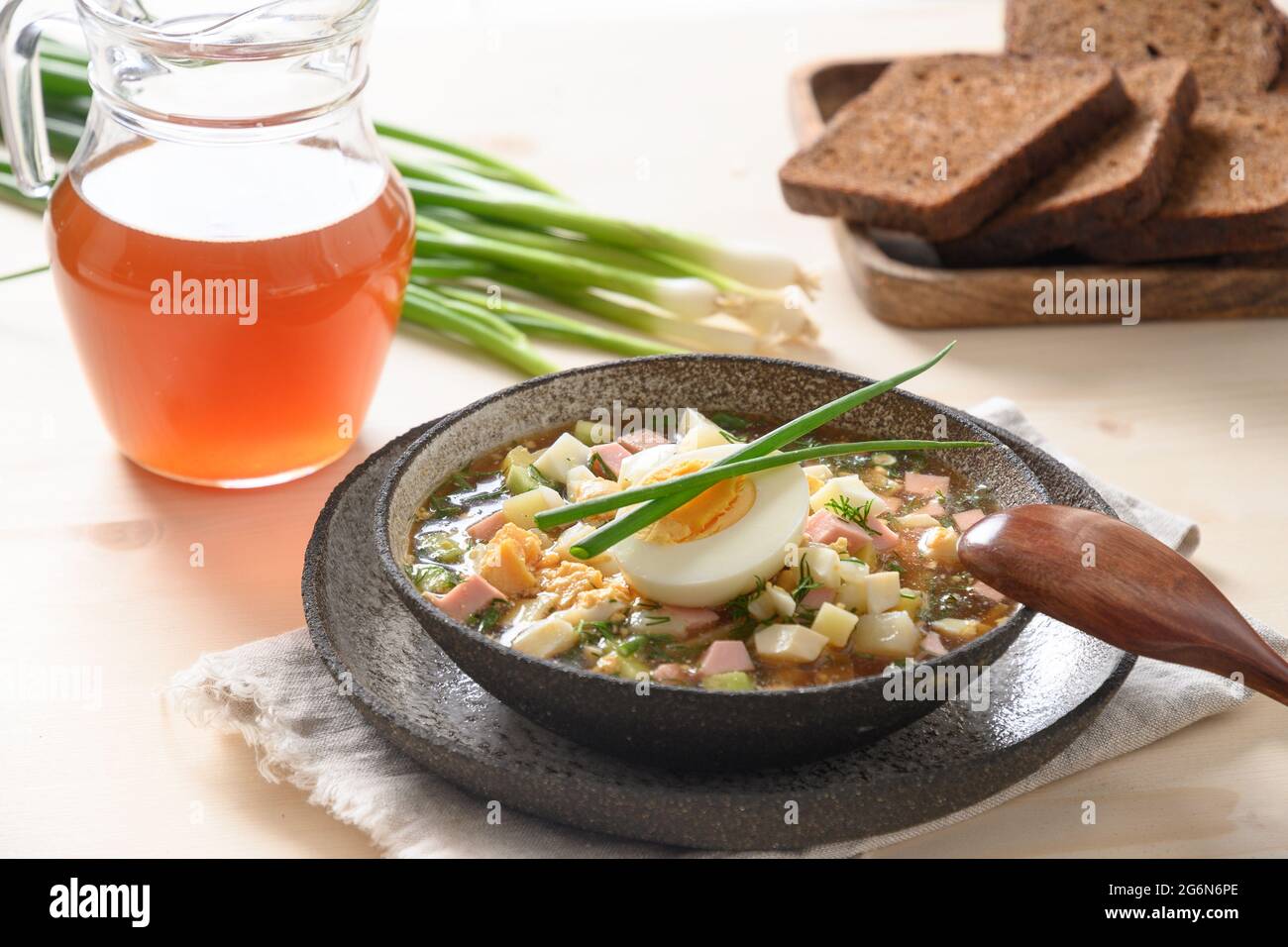 Soupe russe d'été okroshka avec kvass. Okroshka de fraîcheur à base de légumes d'été, concombre, radis, pomme de terre, œufs durs, oignon. Gros plan. Banque D'Images