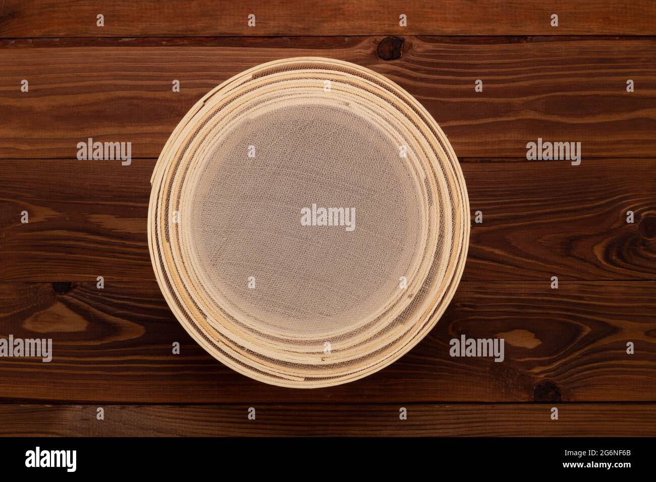 Ancien tamis à farine traditionnel, en bois de hêtre et maille fine, sur fond marron. Placez-le pour tamiser la farine avant la cuisson et la cuisson. Haut Banque D'Images